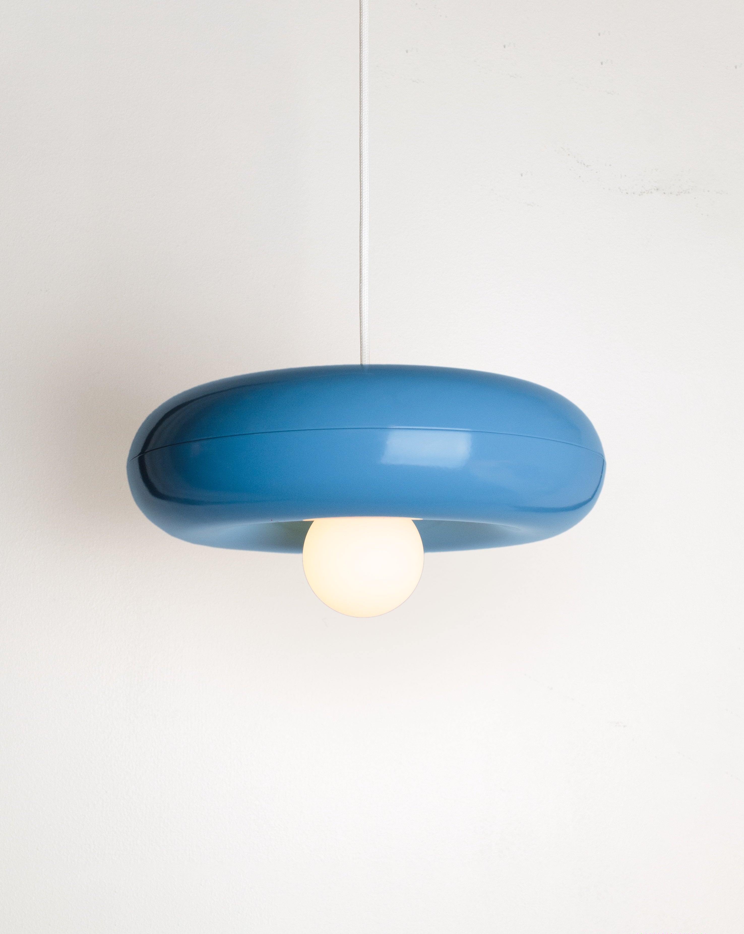 Spin pendant lamp by HAHA studio. The lamp has a round, chubby shape in soft blue.