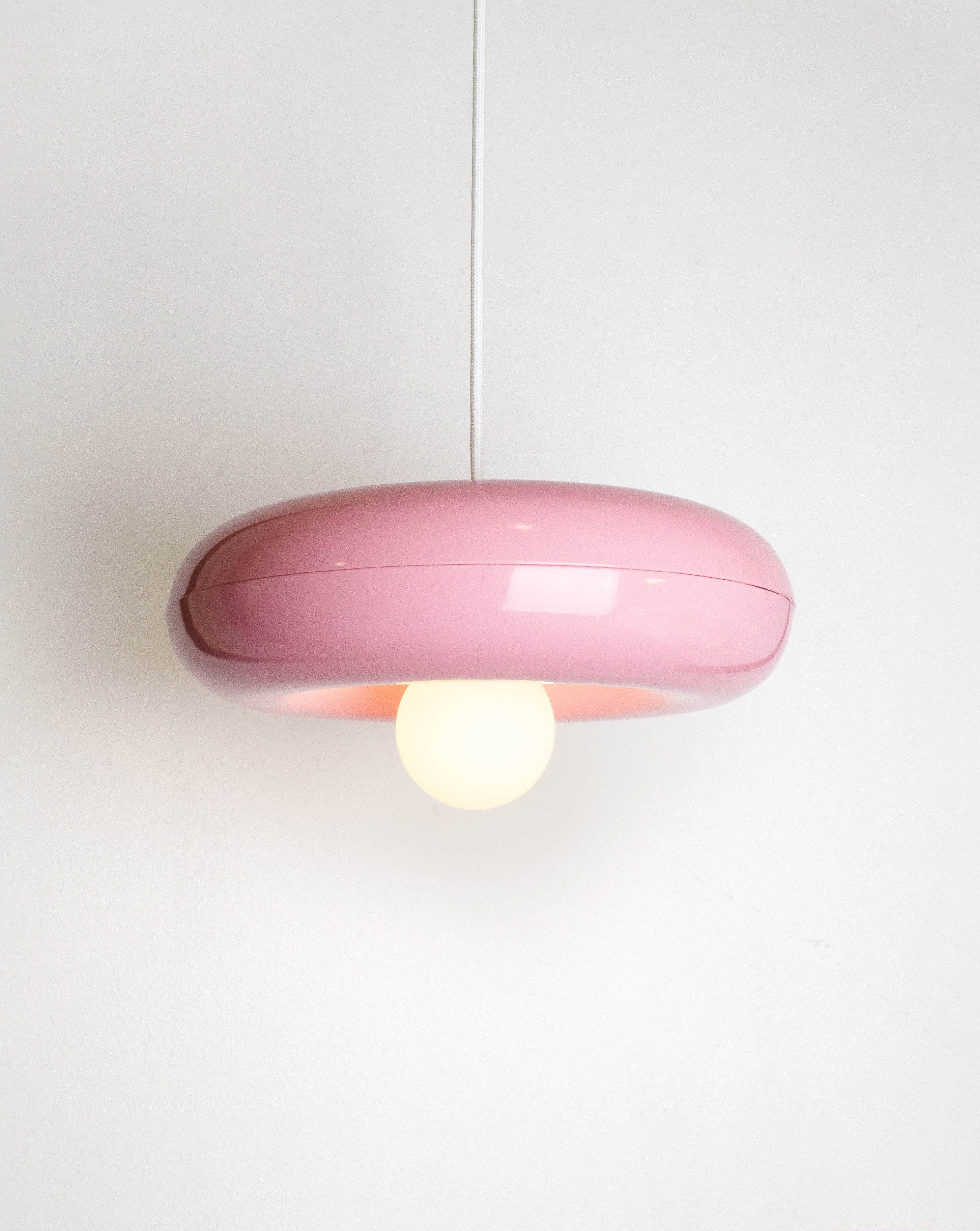Spin pendant lamp by HAHA studio. The lamp has a round, chubby shape in light pink.